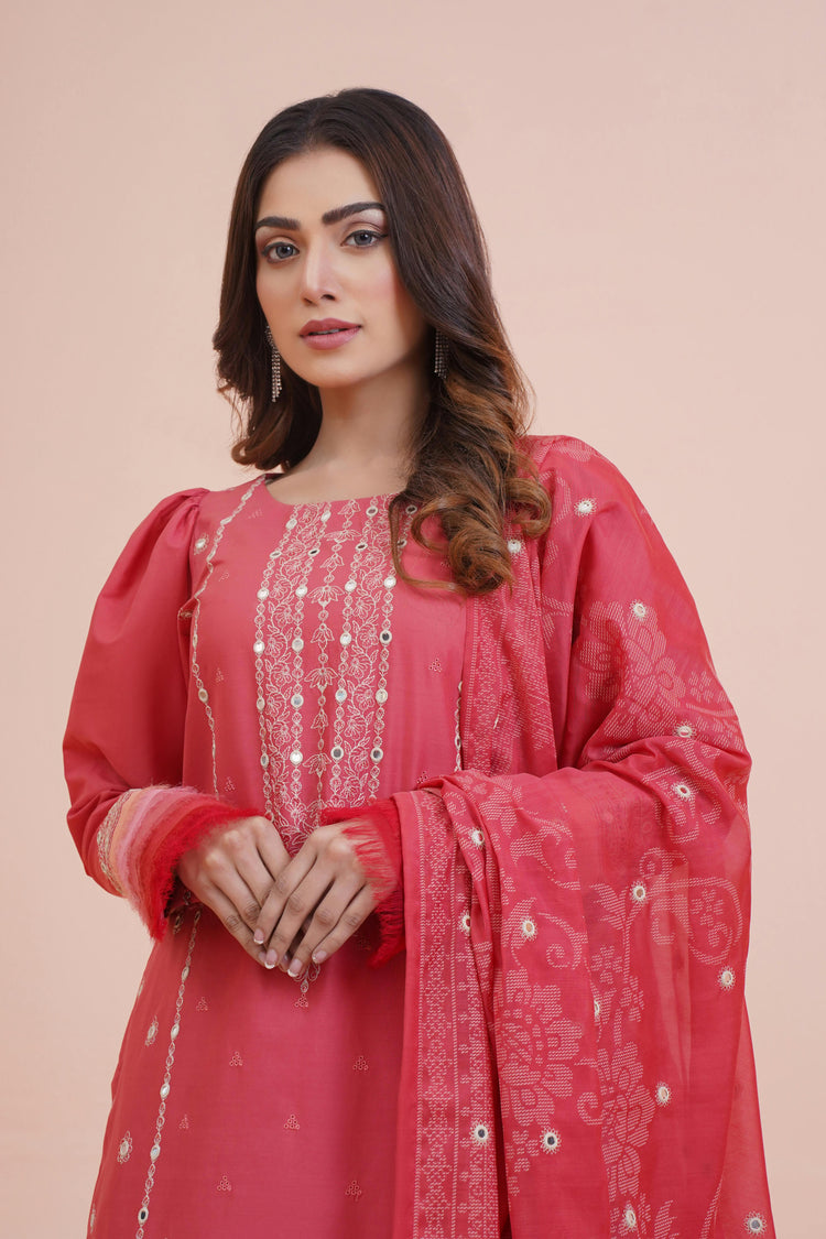 Woman wearing a red embroidered traditional outfit on a pink background